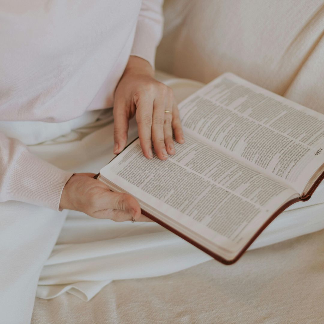 Open Bible on a person's lap illustrating John 14:27 and God's peace for a troubled heart.