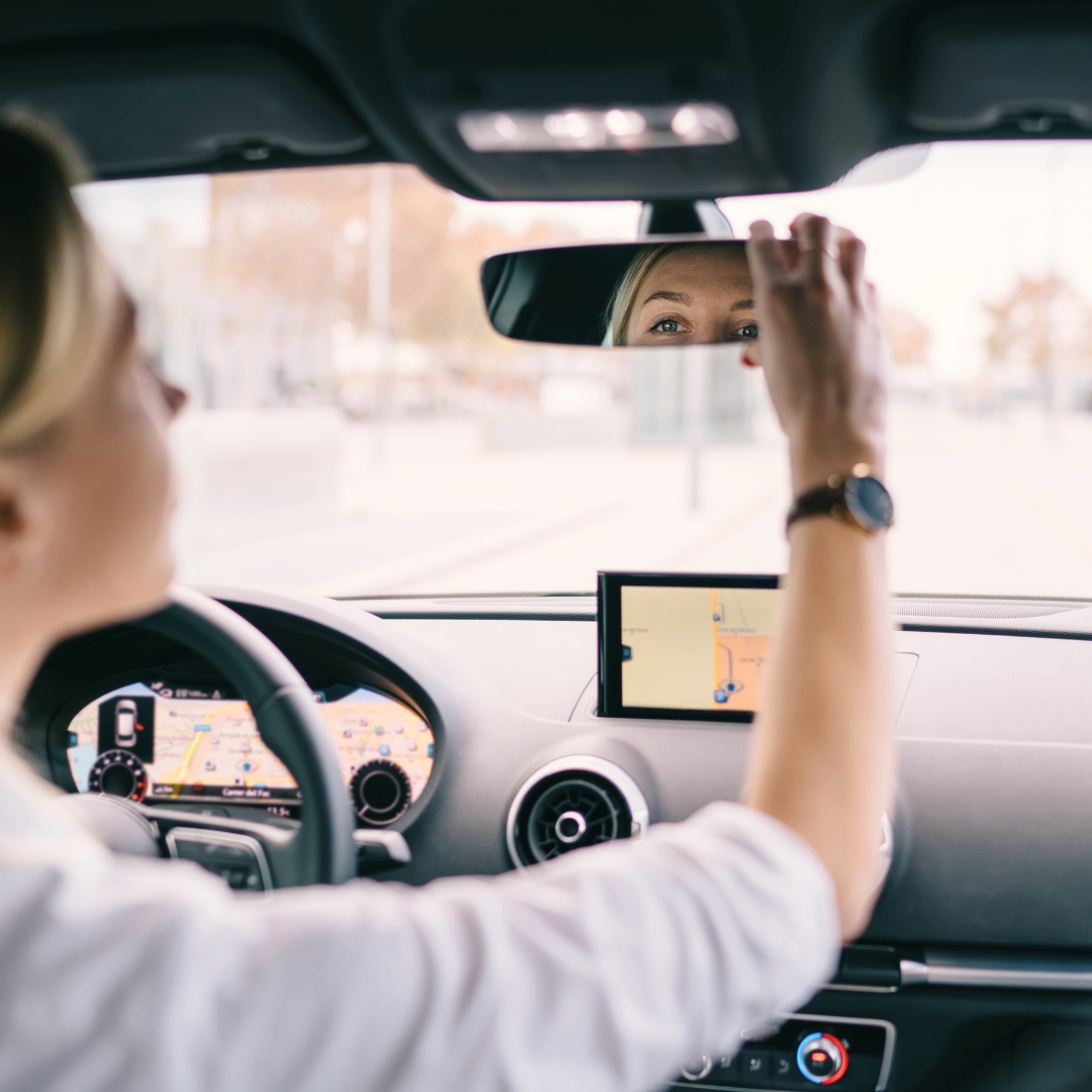freedom-from-strongholds-psalm-25-15.jpg Woman looking in a rearview mirror while driving, illustrating freedom from strongholds based on Psalm 25:15.