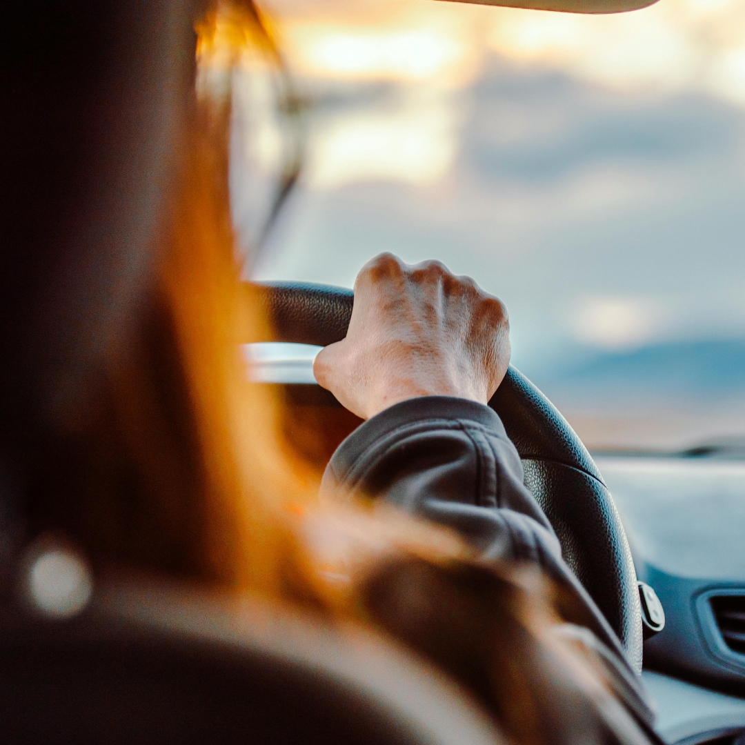 Person driving a car with one hand on the steering wheel, illustrating how making wise choices shapes our direction.