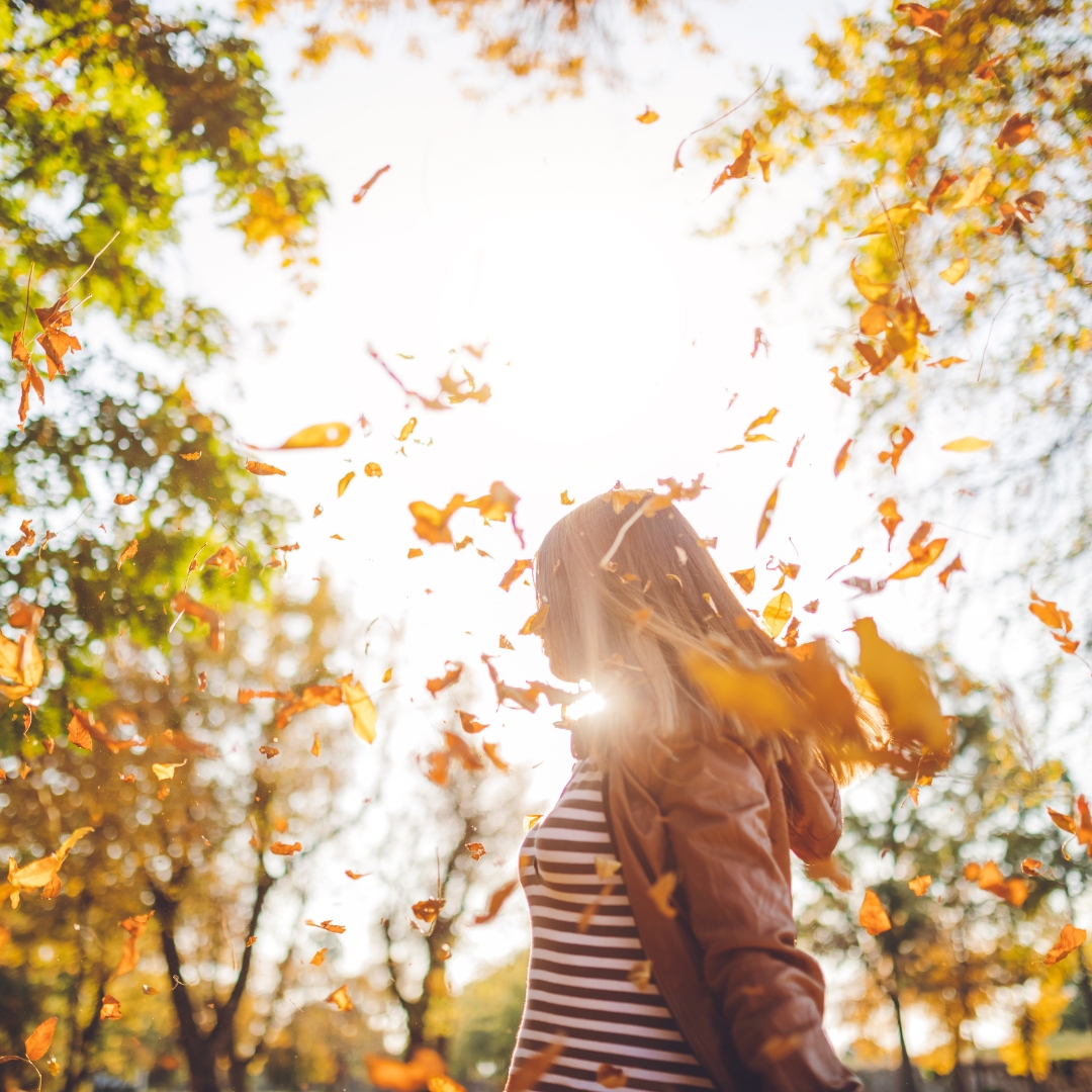 God’s justice in Proverbs 15:1, shown by a woman standing peacefully among falling autumn leaves as a reminder to respond with gentleness and trust God with the outcome.